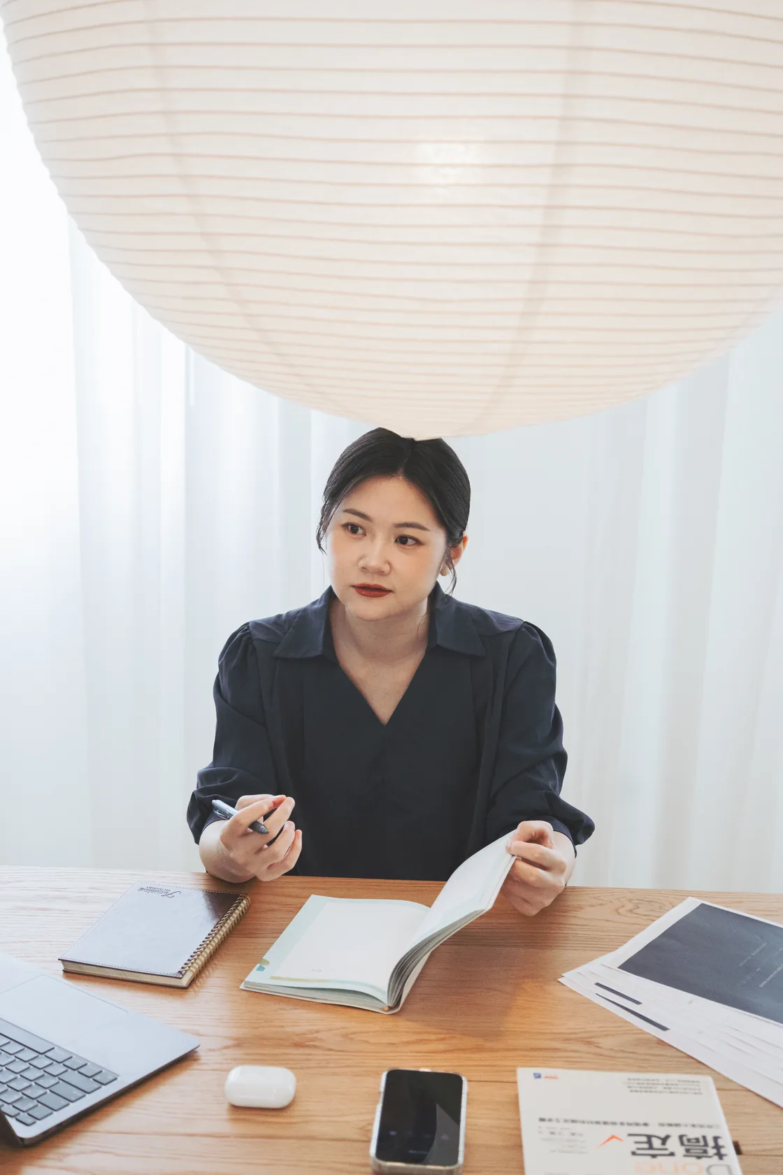 Lauren 在桌前拿著筆,整理品牌想法